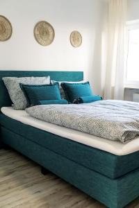 a bedroom with a large bed with blue pillows at in Dattenberg in Dattenberg