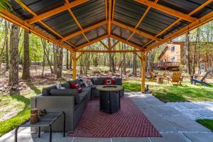 a large wooden pavilion with a couch and a table at Welcome to The Mountain Escape! in Albrightsville