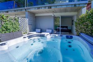 a large hot tub in the middle of a yard at The Glass House & SPA in Caslano