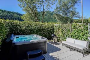 a jacuzzi tub in a yard with a chair at The Glass House & SPA in Caslano