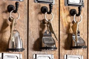 a group of keychains hanging on a wooden wall at Hôtel de Lion sur Mer in Lion-sur-Mer