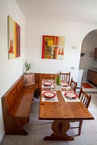a dining room with a wooden table and chairs at B&B del Porto in Bosa Marina