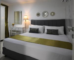um quarto com uma grande cama branca e uma mesa em Nest Residence em Jacarta