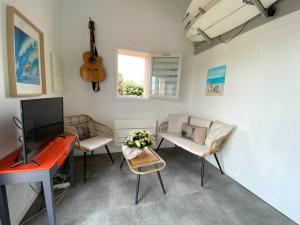 a living room with a red desk and a guitar at maison vue sur mer dans les dunes avec acces direct aux plages in Bretignolles-sur-Mer