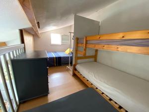 a small room with two bunk beds and a desk at maison vue sur mer dans les dunes avec acces direct aux plages in Bretignolles-sur-Mer +15 photos