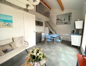 a living room and kitchen with a table and chairs at maison vue sur mer dans les dunes avec acces direct aux plages in Bretignolles-sur-Mer