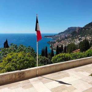 czerwona flaga na ścianie z widokiem na ocean w obiekcie Joli deux pièces vieux village de Roquebrune-Cap-Martin w mieście Roquebrune-Cap-Martin