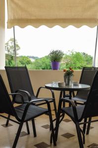 ein Tisch mit zwei Stühlen und ein Tisch mit Blumen darauf in der Unterkunft Coro Cozy House in Potamós