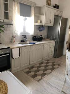 a kitchen with white cabinets and a checkered floor at FYKIA HOUSE in Naousa