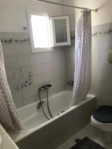 a bathroom with a tub and a toilet and a window at FYKIA HOUSE in Naousa +7 photos