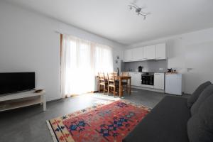 ein Wohnzimmer mit einem Tisch und einer Küche in der Unterkunft Comfortably Losone in Losone