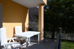 een witte tafel en stoelen op een patio bij Comfortably Losone in Losone