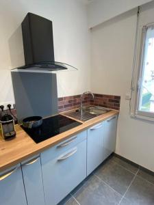 a kitchen with a sink and a stove top oven at Studio lumineux de 35m2 au cœur de Solesmes in Solesmes