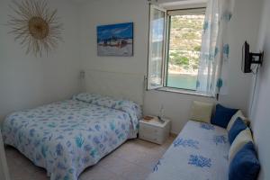 a small bedroom with a bed and a window at B&B del Porto in Bosa Marina