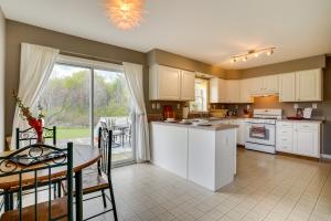 cocina con armarios blancos, mesa y ventana en Freeville Home with Covered Porch Near Cayuga Lake!, en Freeville