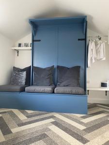 una cama azul con almohadas en una habitación en The Hen House 