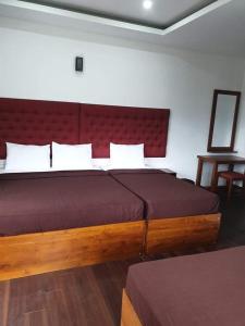 a bedroom with a large bed with a red headboard at Villa Nive in Nuwara Eliya