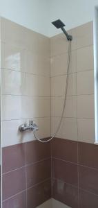 eine Dusche mit einem an der Wand befestigten Schlauch in der Unterkunft Apartamenti 204 in Shëngjin