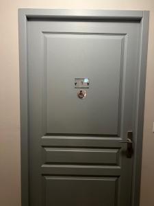 a grey door with a knob on it at Hôtel de Lion sur Mer in Lion-sur-Mer
