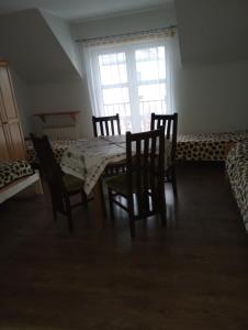 a dining room with a table and chairs and a window at Gospoda Rycerska in Szydłów