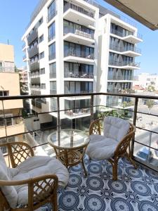 a balcony with chairs and a table and a building at Sea Suites in Tel Aviv