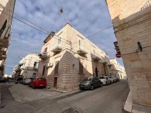 een gebouw met auto's geparkeerd aan de kant van een straat bij New home Orizzonte in Ruvo di Puglia