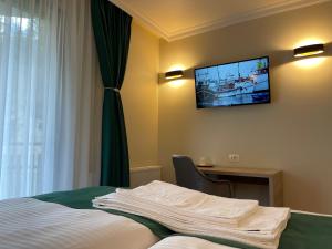 um quarto de hotel com uma cama e uma televisão na parede em PENSIUNEA SKY HUB em Arieşeni