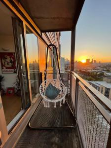 a hammock on a balcony with a view of a city at Whitechapel Two Bedroom Luxury Apartment - Free Private Parking - City Views in London