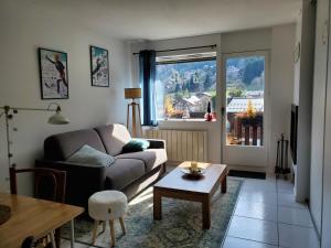 uma sala de estar com um sofá e uma mesa em Studio avec petit balcon et cheminée - Grand Massif em Les Carroz d'Araches