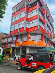 ein roter Jeep, der vor einem Gebäude geparkt ist in der Unterkunft Hotel las Corocoras del llano in Villavicencio