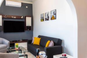 a living room with a couch and a tv at Antiopi's Vacation House in Argyrádes