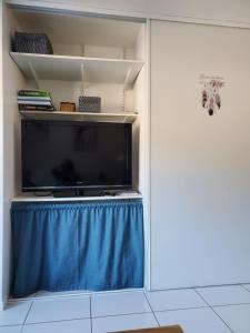 a living room with a tv and a blue curtain at Studio avec petit balcon et cheminée - Grand Massif in Les Carroz d'Araches