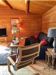 een woonkamer met een bank en een tafel bij Lakefront Cabin in Magnor