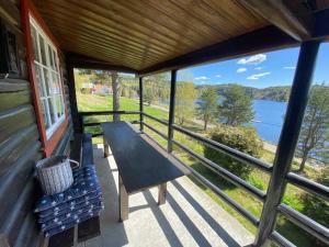 a porch with a bench and a view of a lake at Lakefront Cabin in Magnor