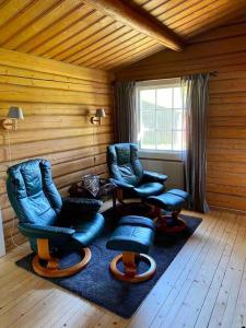 een kamer met 3 stoelen, een tafel en een raam bij Lakefront Cabin in Magnor