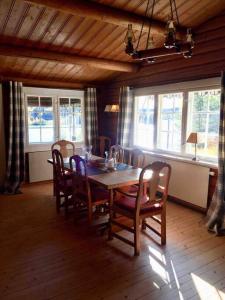 een eetkamer met een houten tafel en stoelen bij Lakefront Cabin in Magnor