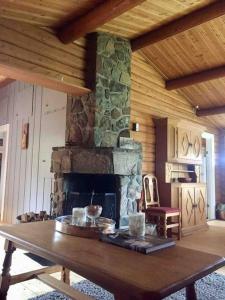 a living room with a stone fireplace and a table at Lakefront Cabin in Magnor