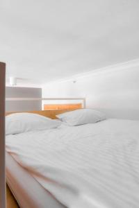 a white bed with two white pillows on it at RYNEK Stare Miasto Apartment 4 - Klima Netflix in Wrocław