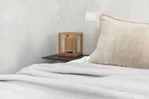 a bed with a wooden night stand next to a pillow at Casa Esther in Siracusa