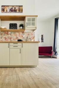 cocina con armarios blancos y sofá rojo en Domus Bama, en Ceglie Messapica