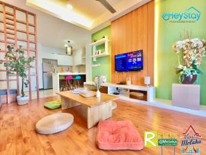 sala de estar con mesa y TV en Silver Scape Residence Melaka Raya By Heystay Management en Melaka