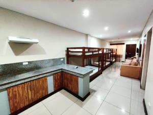 a room with a kitchen and a bunk bed at Executive Tulip Apartelle in Davao City