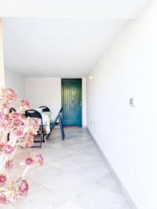 奧里斯塔諾的住宿－Hibryd: in centro, a due passi dal mare，一间拥有粉红色花卉和蓝色门的房间