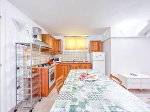 a kitchen with a table and a white refrigerator at Hibryd: in centro, a due passi dal mare in Oristano