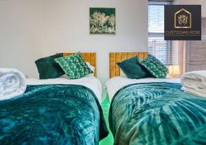 2 Betten in einem Zimmer mit blauer und grüner Bettwäsche in der Unterkunft Two bedroom - Central Peterborough - New Year Discount in Peterborough