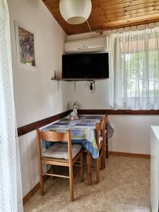 a dining room with a table and a tv at Apartment Studio Zvonka in Zambratija