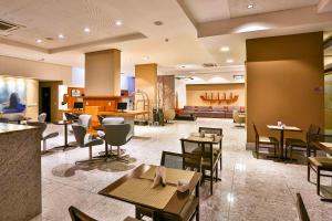 a restaurant with tables and chairs in a lobby at Flat Beach Class Executive - Beira Mar de Boa Viagem in Recife