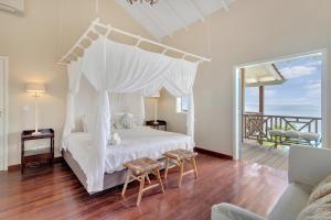a bedroom with a white bed with a canopy at Villa Shores 32 in Kralendijk +32 photos