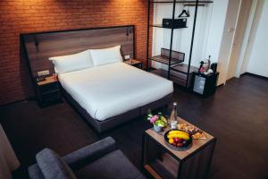 a bedroom with a bed and a table with a bowl of fruit at ONOMO Hotel Casablanca Sidi Maarouf in Casablanca