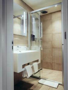 La salle de bains est pourvue d'un lavabo et d'une douche. dans l'établissement ONOMO Hotel Casablanca Sidi Maarouf, à Casablanca